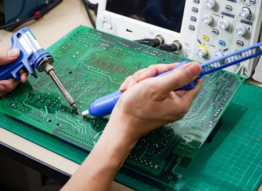 operating engineer Repair soldering the circuit board of the electronic device on the table.board repair cnc machine