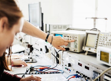 Some engineering students using technical equipment during a class at university.